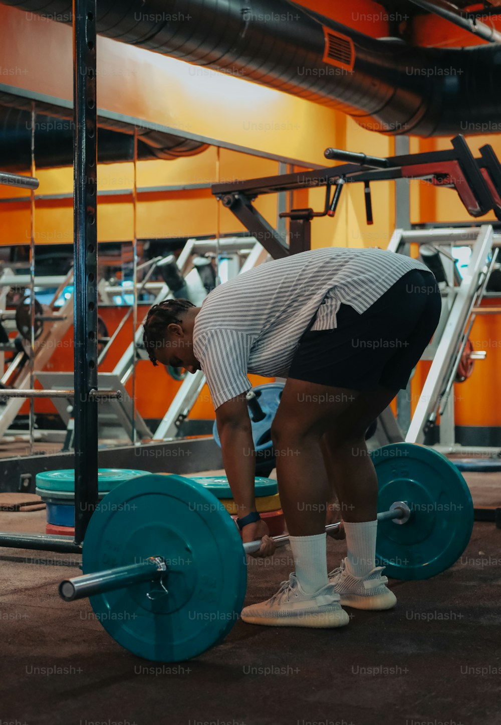 a woman squatting down with a barbell in front of her