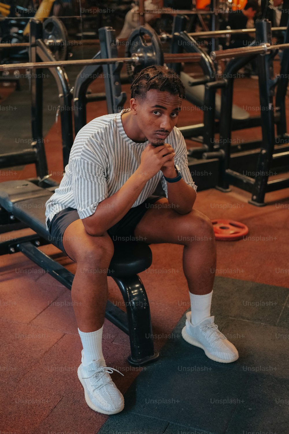 Ein Mann sitzt auf einer Bank in einem Fitnessstudio