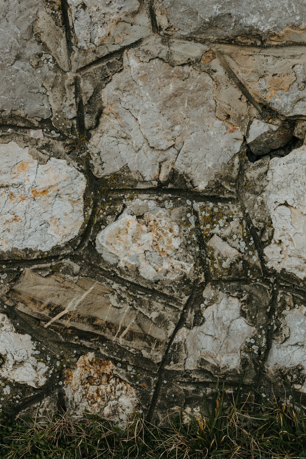 a teddy bear sitting on top of a stone wall