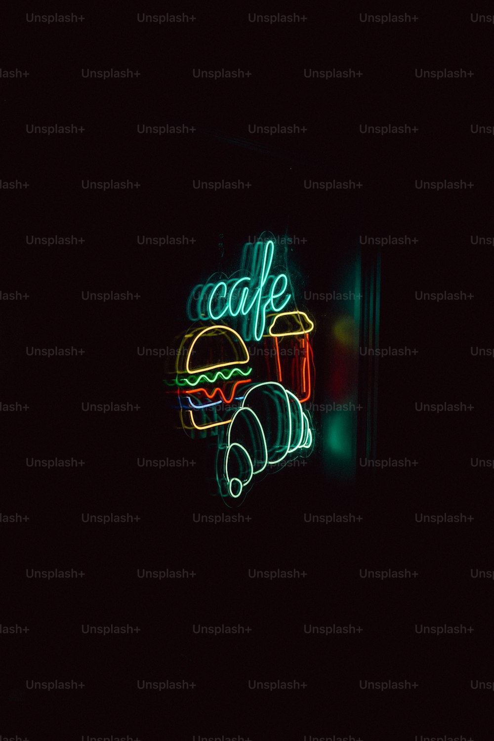 a neon sign that says cafe on a dark background