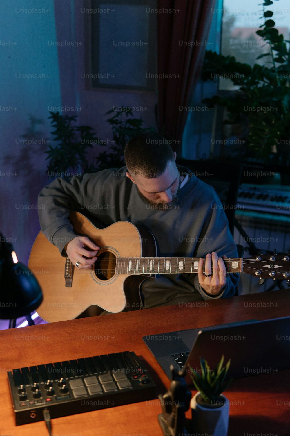 Un uomo seduto a una scrivania che suona una chitarra