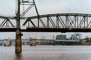 a bridge over a body of water with a city in the background