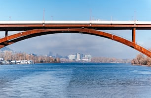 un pont sur un plan d’eau avec une ville en arrière-plan