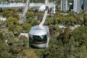 a silver train traveling through a lush green forest