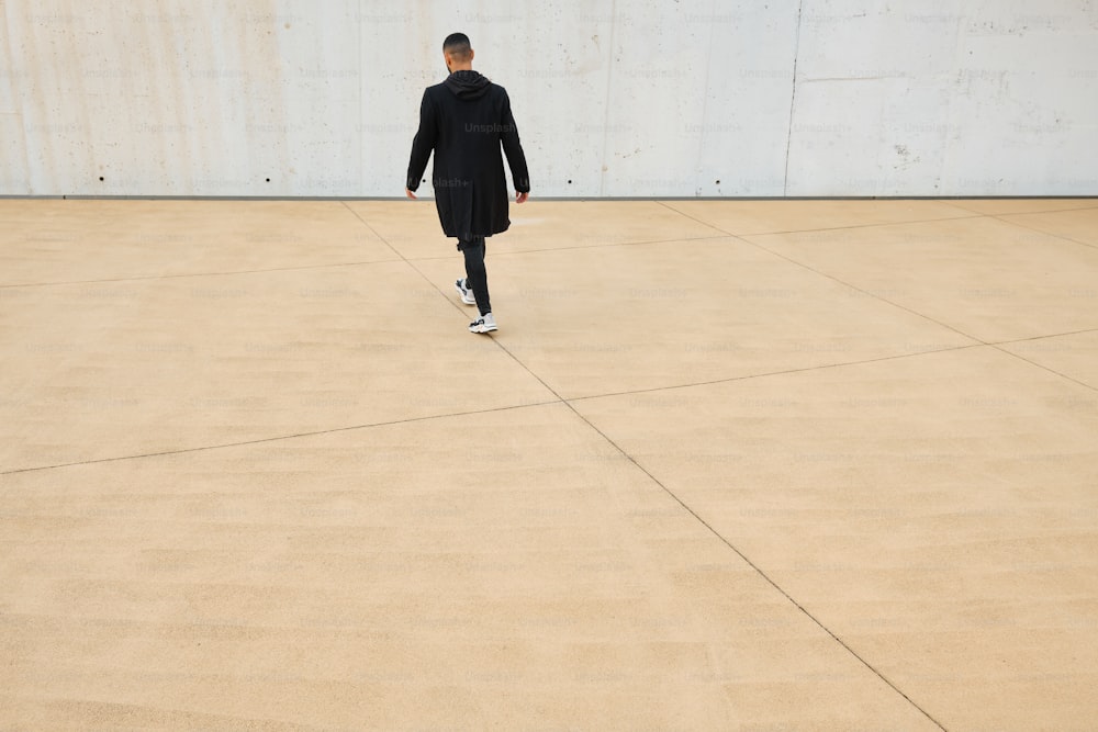 a man in a black coat is walking