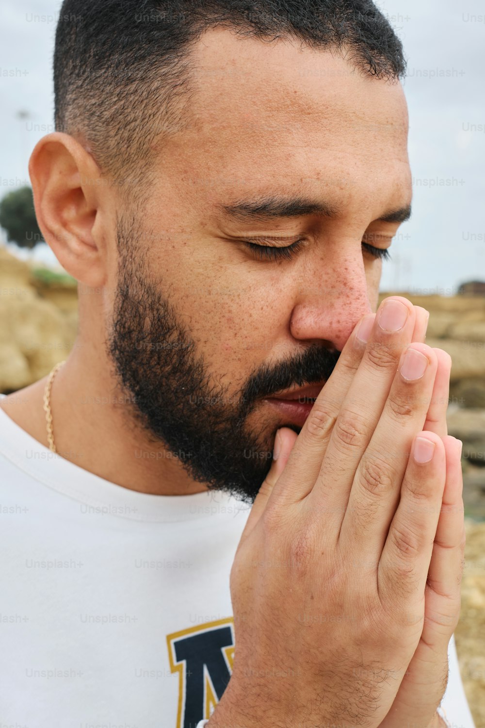 um homem segurando as mãos juntas para orar