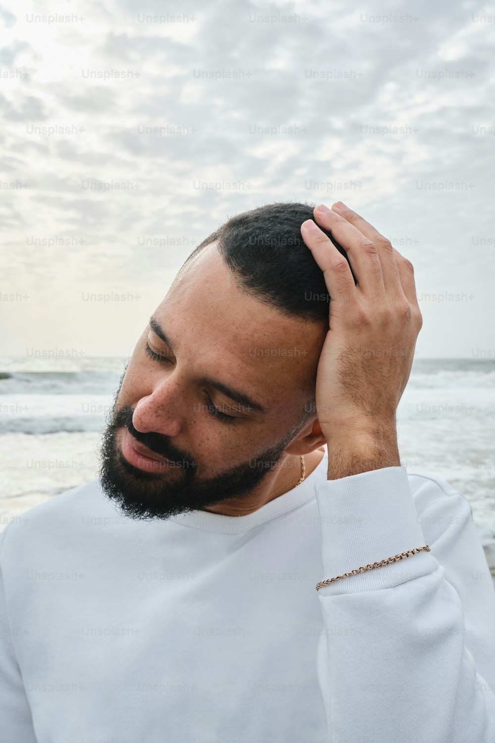 Un uomo con la barba è in piedi sulla spiaggia
