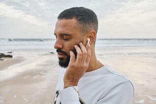 a man talking on a cell phone on a beach