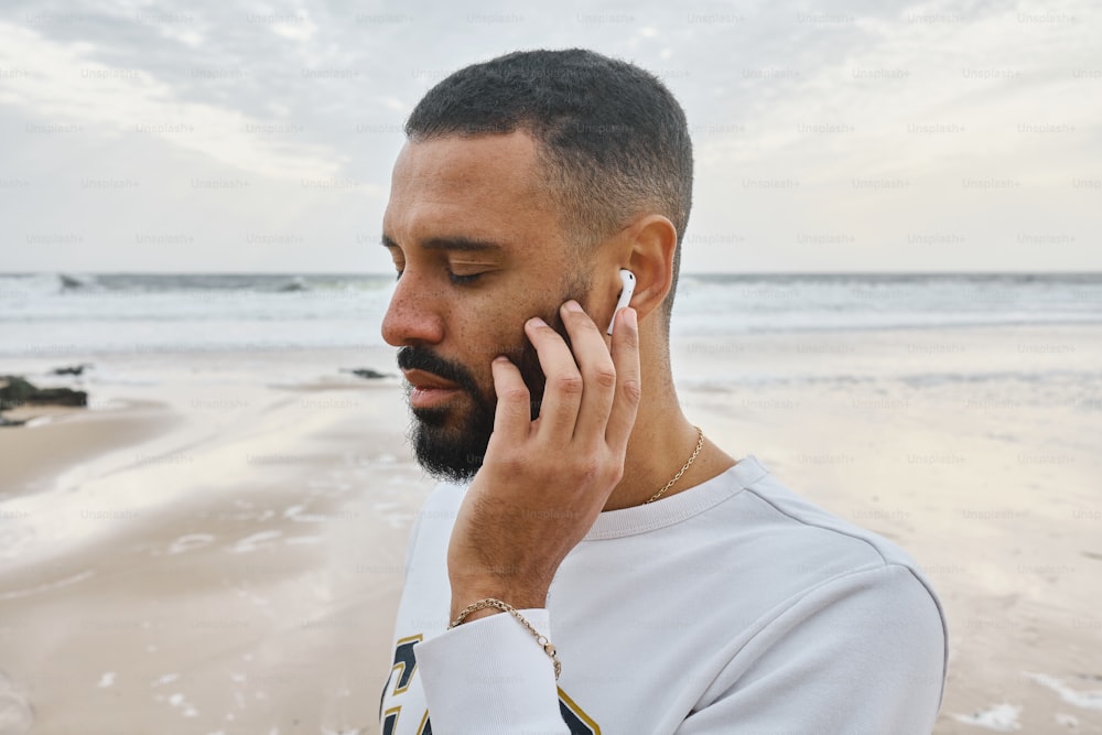a man talking on a cell phone on a beach