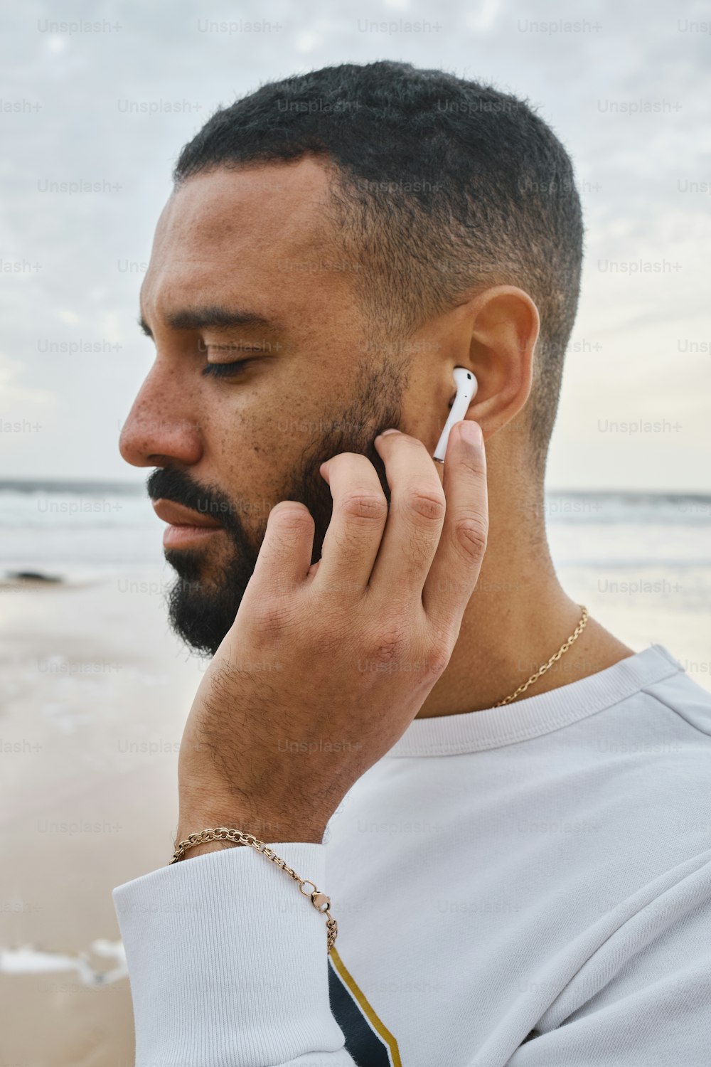 a man talking on a cell phone on the beach