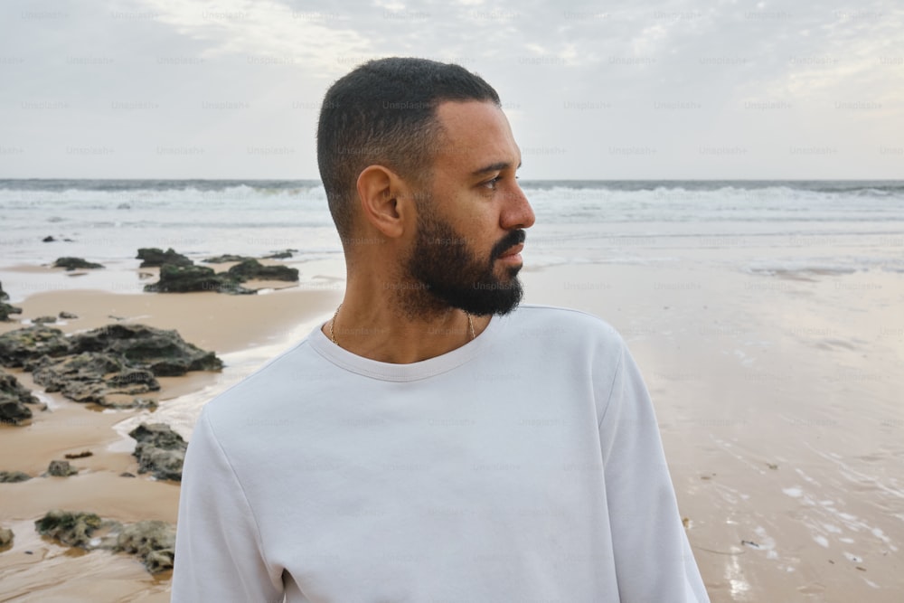 a man standing on a beach next to the ocean