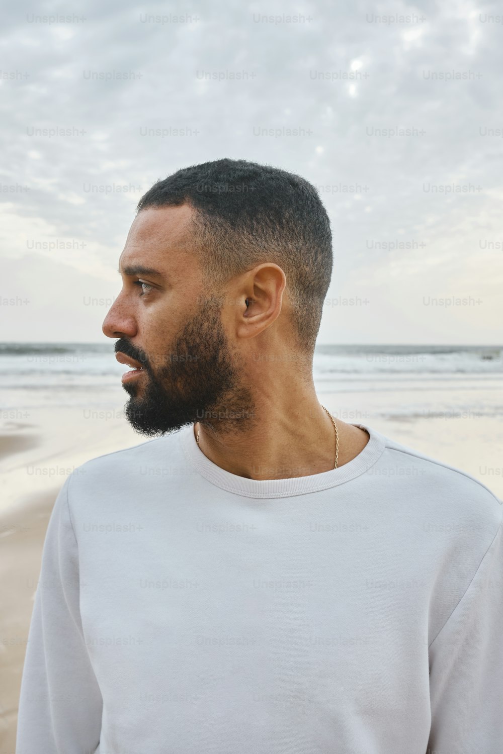 Ein Mann mit Bart steht am Strand