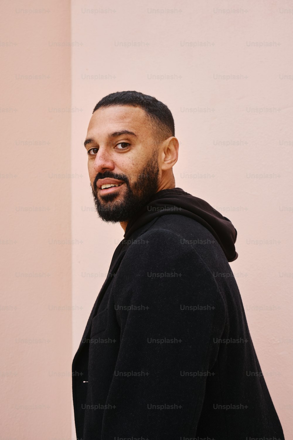 Un uomo con la barba e la giacca nera