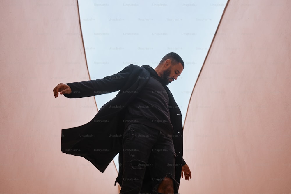 a man in a black coat is walking up a flight of stairs