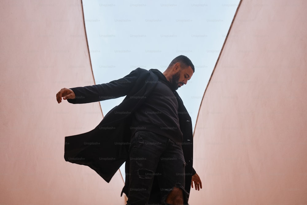 Un homme en manteau noir monte un escalier