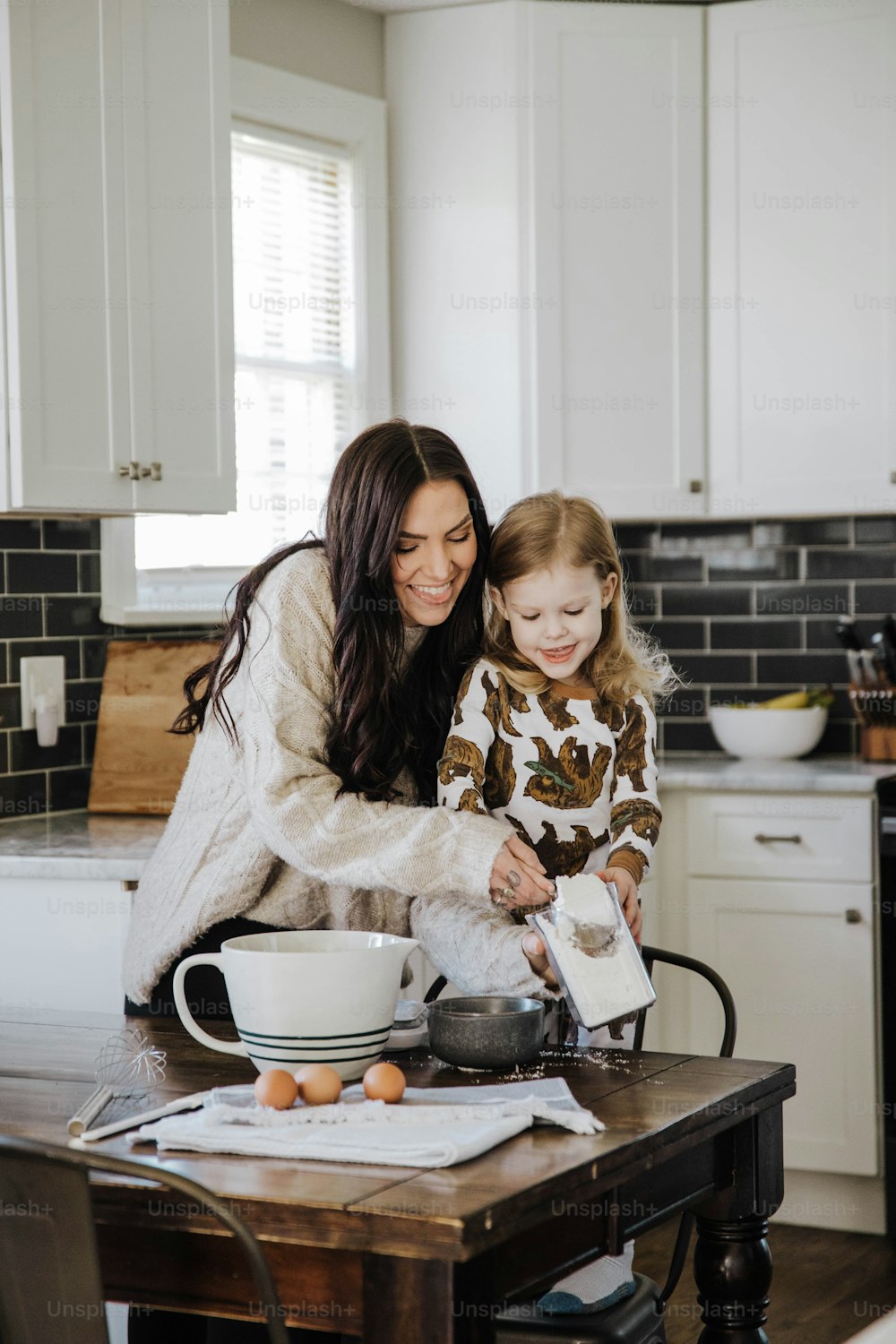 a woman and a little girl in a kitchen
