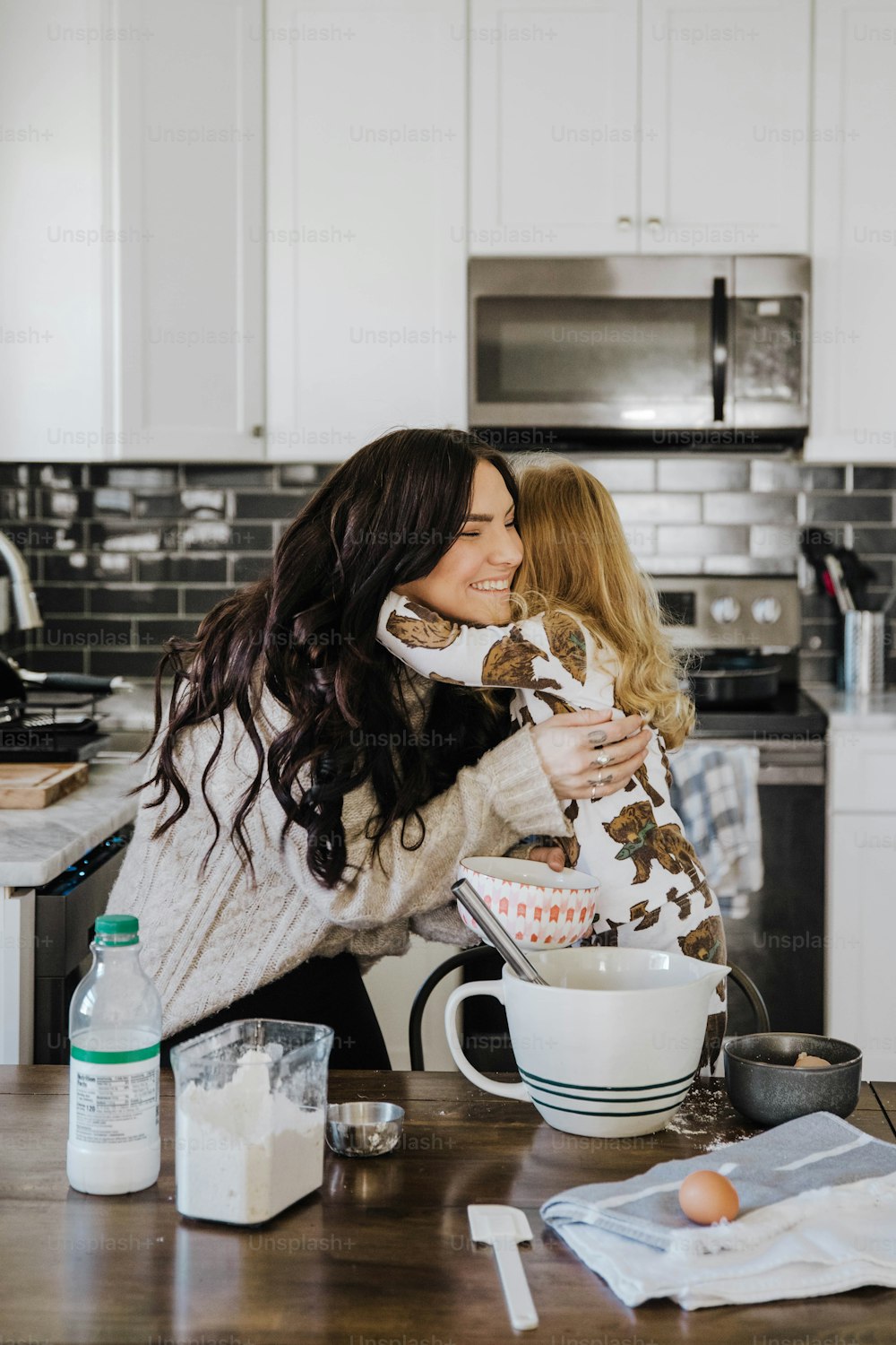 a woman holding a baby in a kitchen