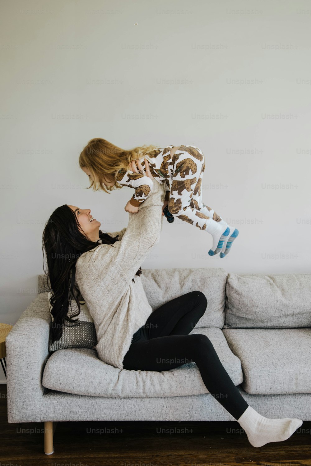 a woman sitting on a couch holding a stuffed animal