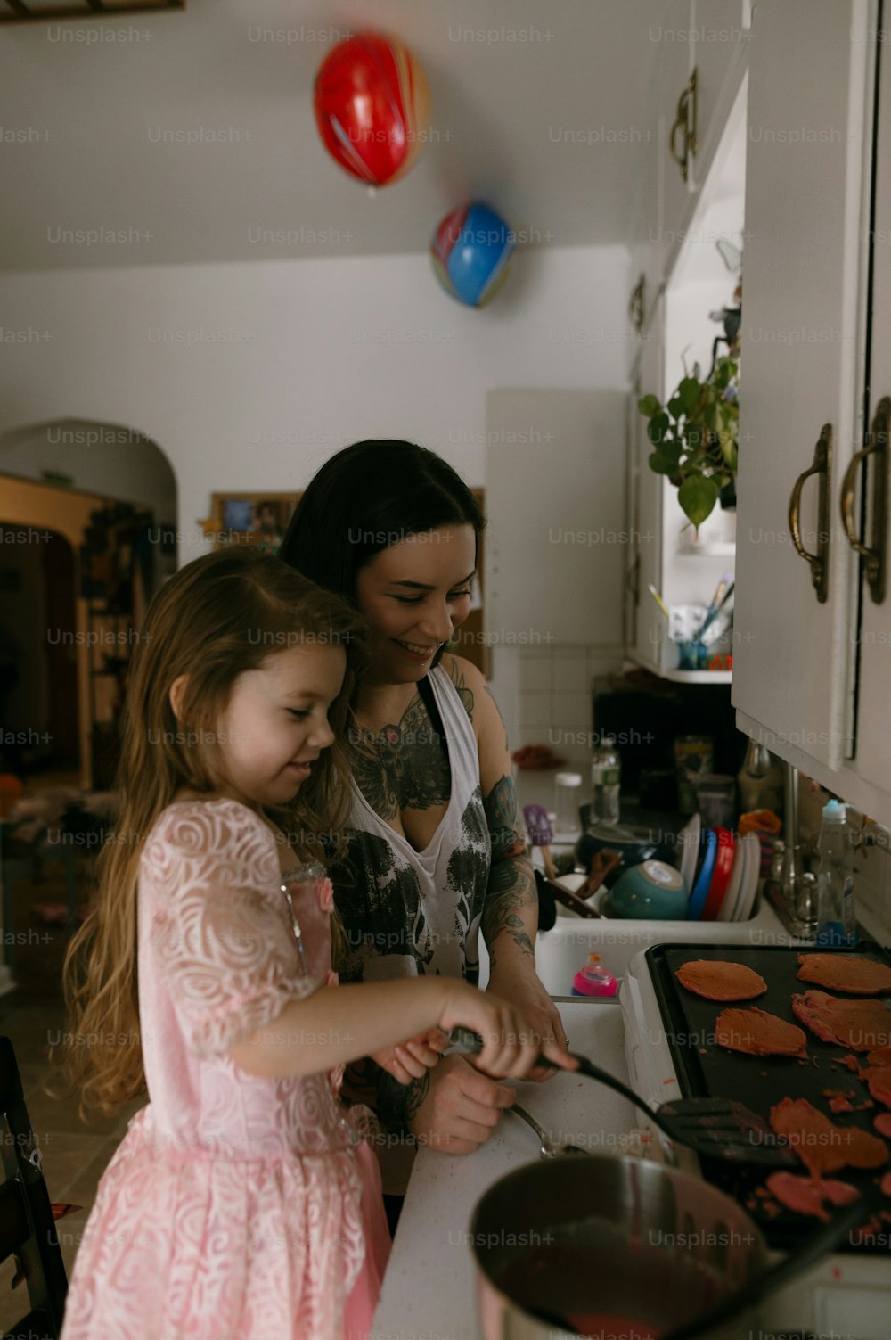 a woman and a little girl cooking in a kitchen
