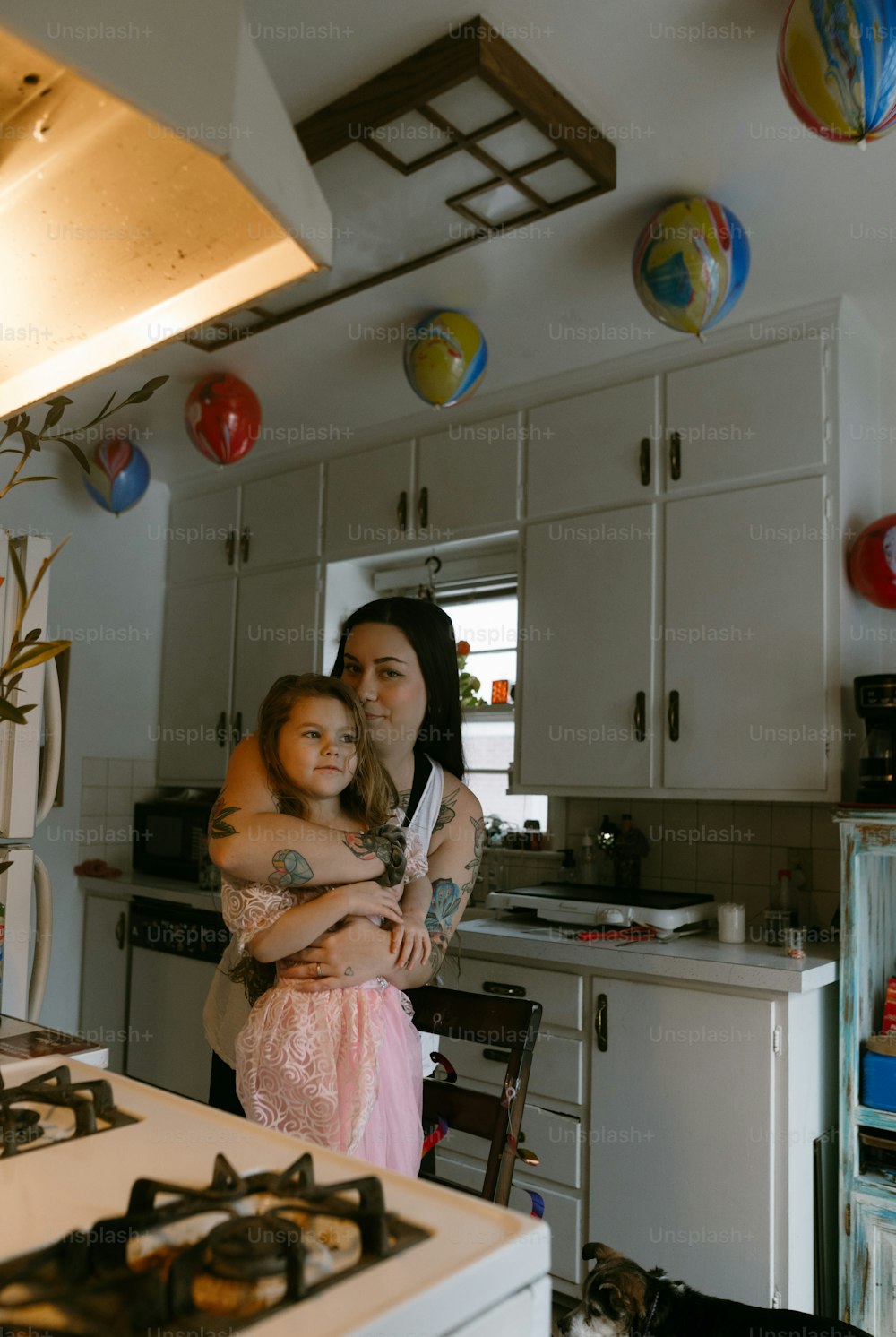 a woman holding a little girl in a kitchen