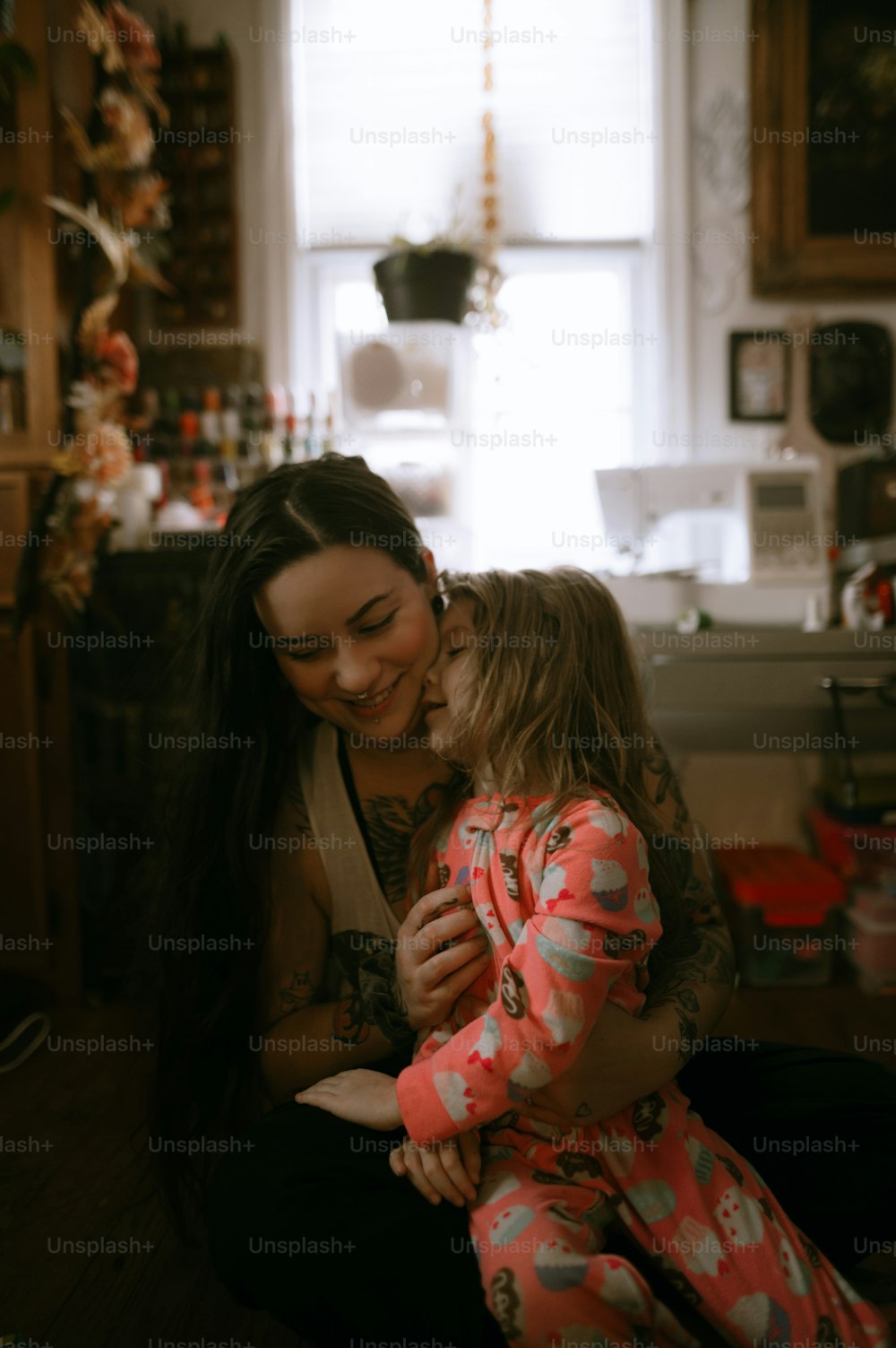 uma mulher e uma menina sentada em uma cozinha