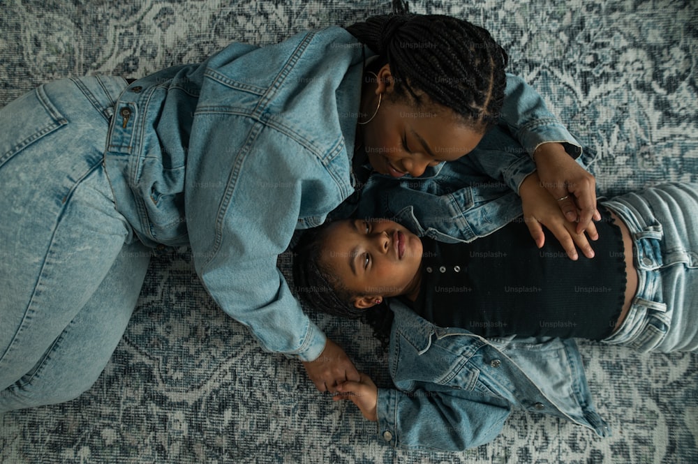 a couple of people laying on top of a rug