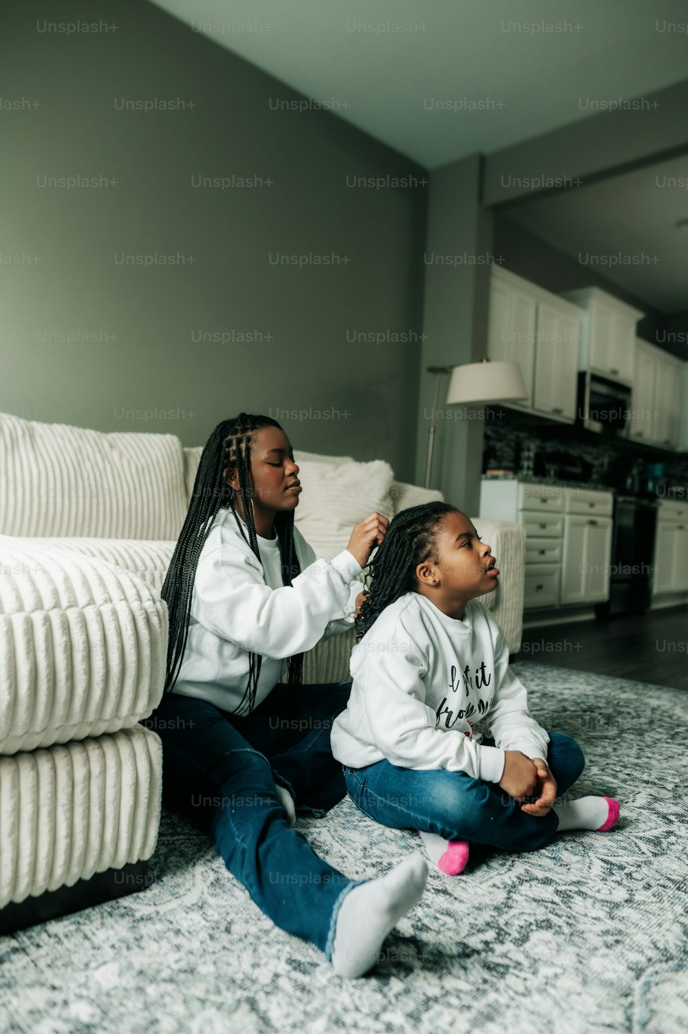 a woman combing a child's hair in a living room