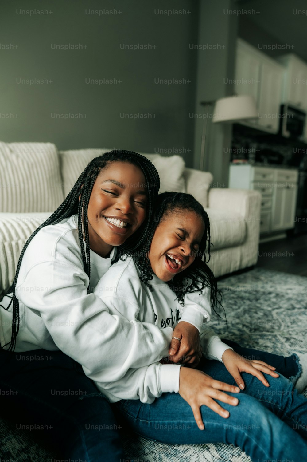 a mother and daughter sitting on the floor together