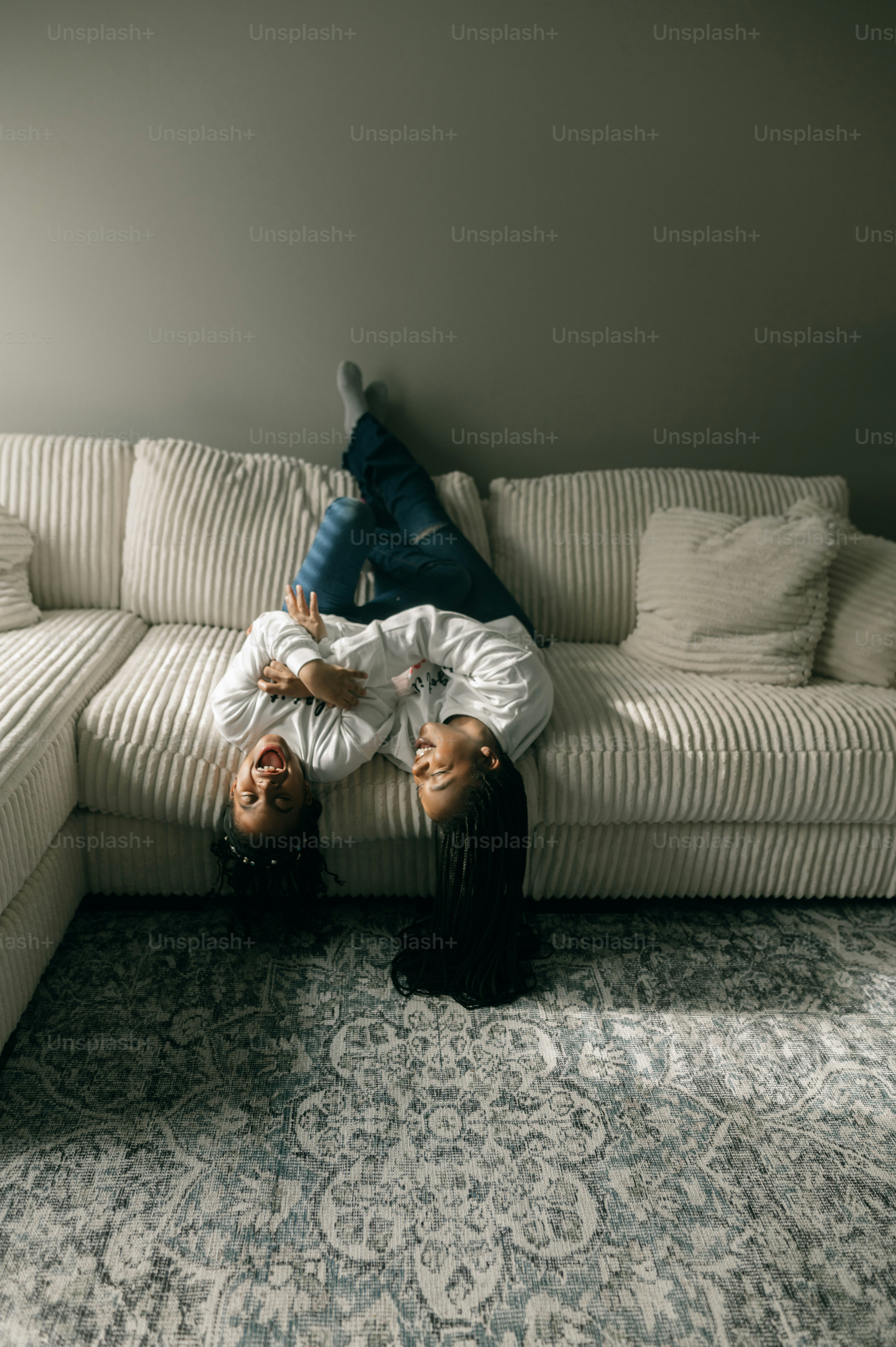 a woman laying on top of a white couch