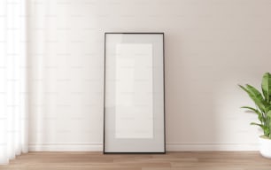 a picture frame sitting on a wooden floor next to a potted plant