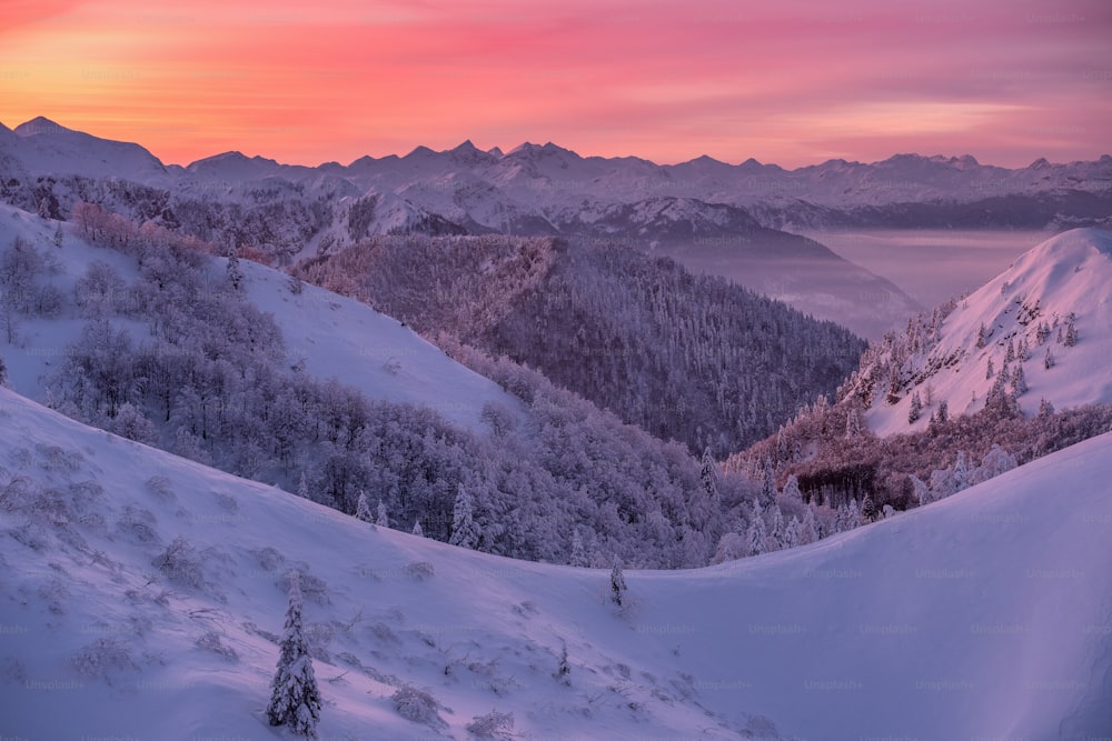 a sunset view of a snowy mountain range