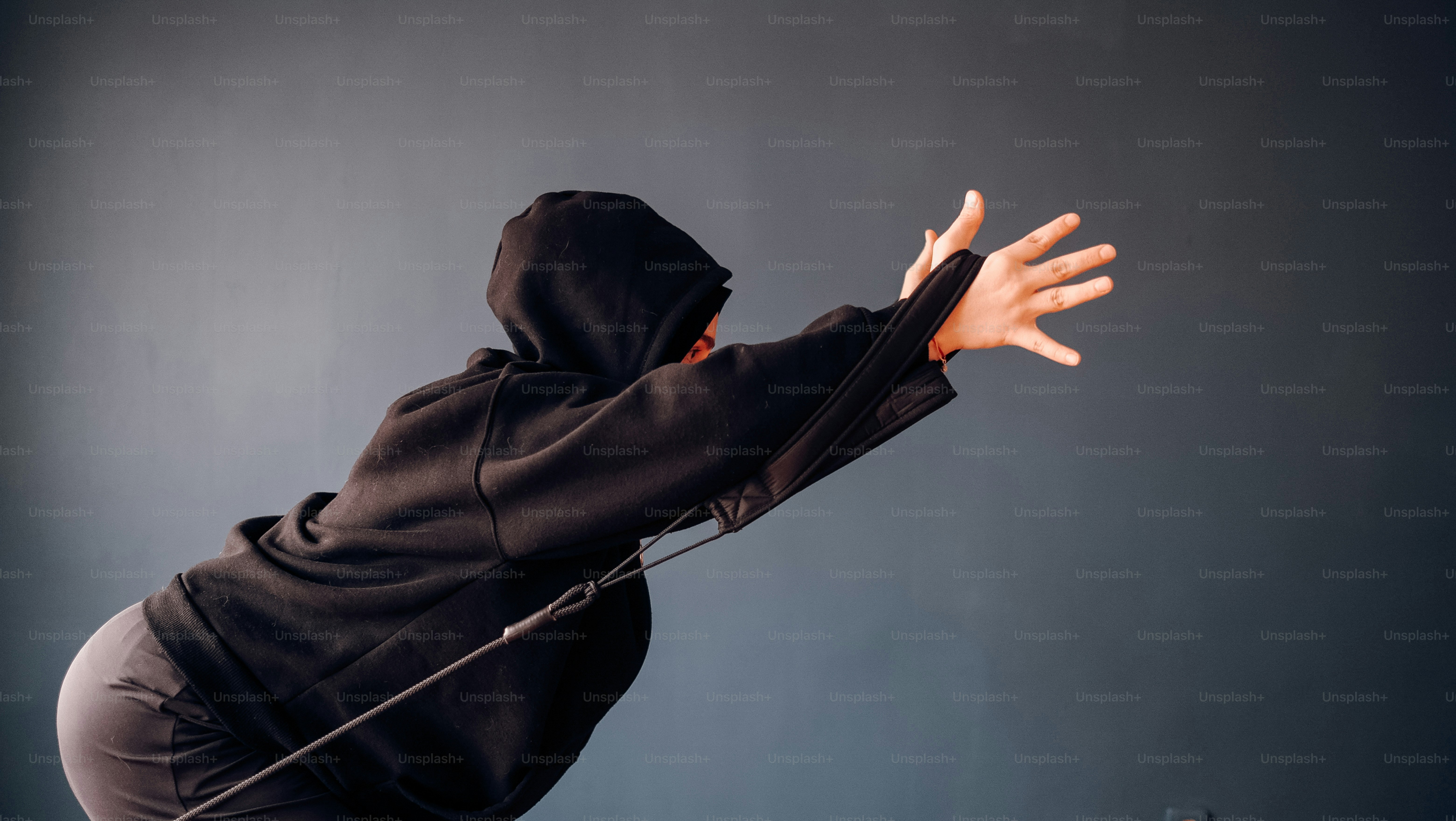 a person in a black hoodie is holding a microphone