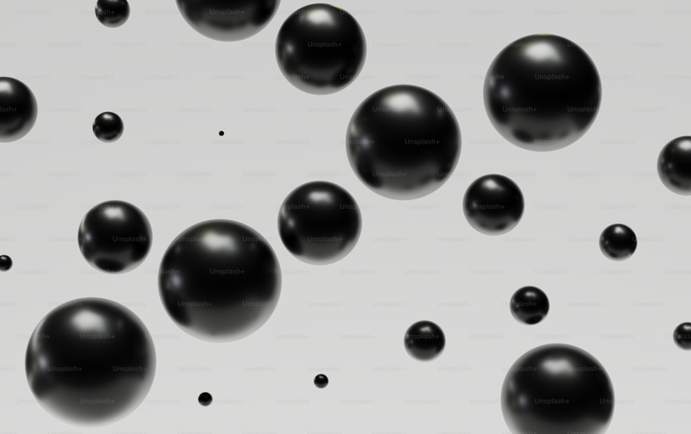 um grupo de bolas pretas flutuando em cima de uma superfície branca