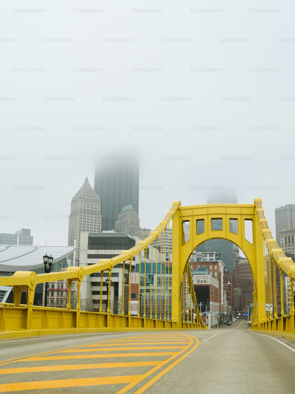 a yellow bridge with buildings in the background