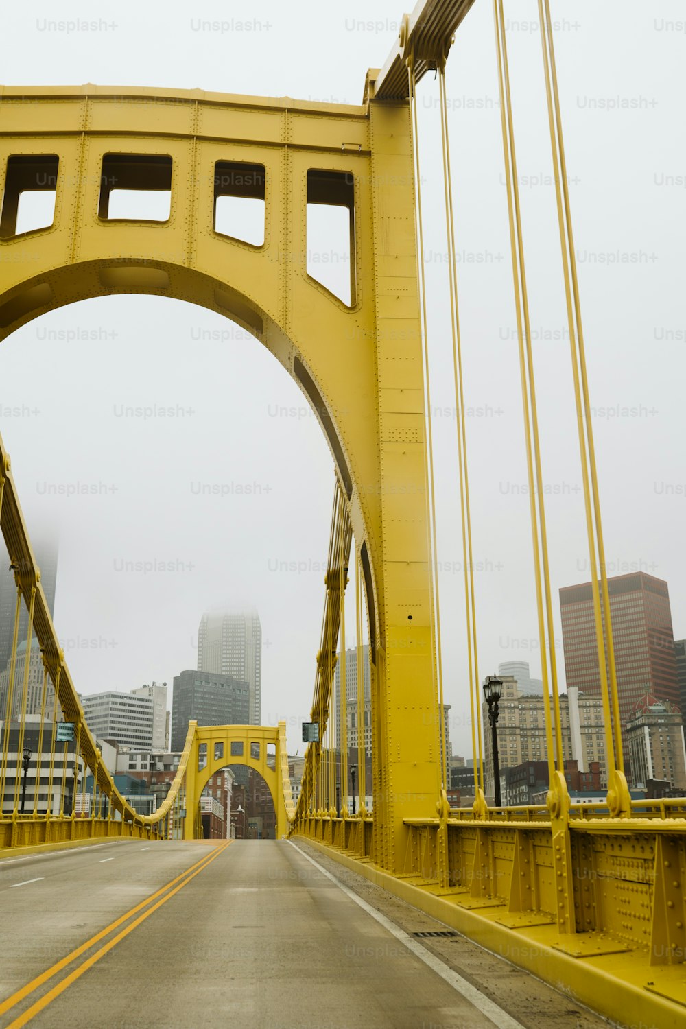 Eine gelbe Brücke mit einer Stadt im Hintergrund