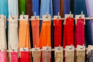 un étalage de pantalons de différentes couleurs accrochés à un support