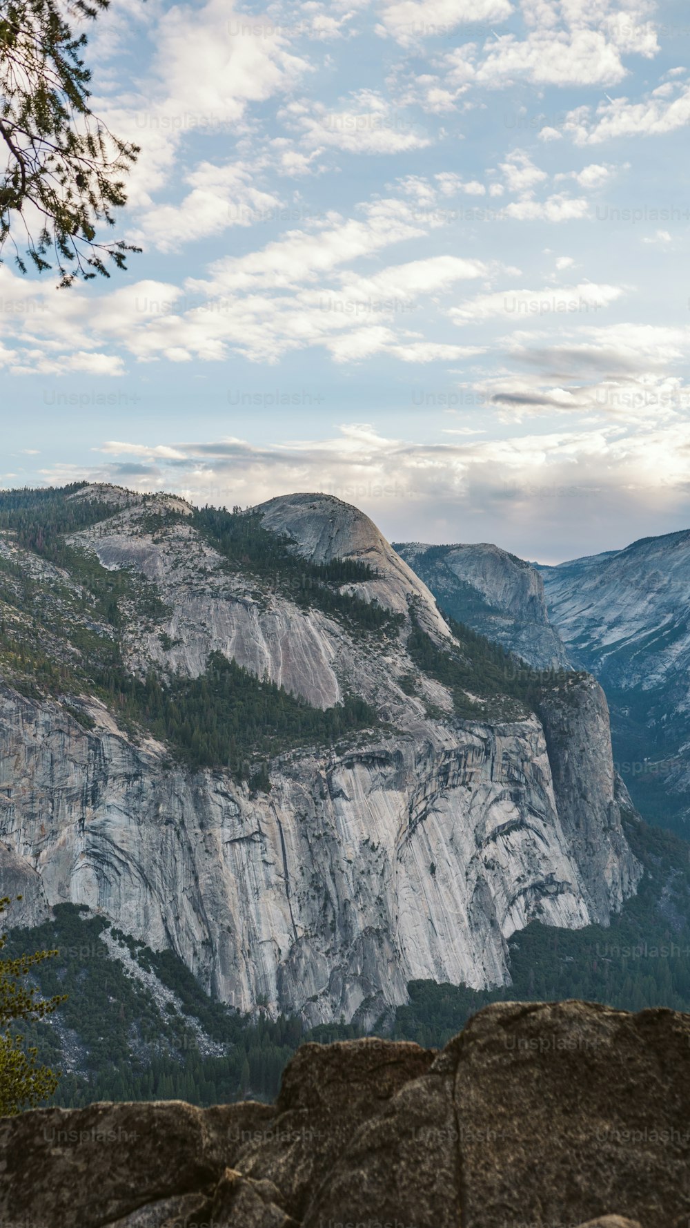 a view of a mountain range with trees and mountains in the background