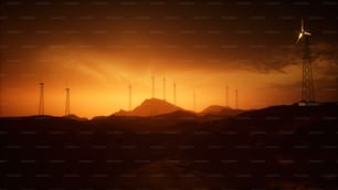 Un groupe de moulins à vent sur une colline au coucher du soleil
