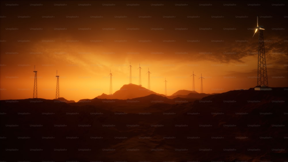 um grupo de moinhos de vento em uma colina ao pôr do sol