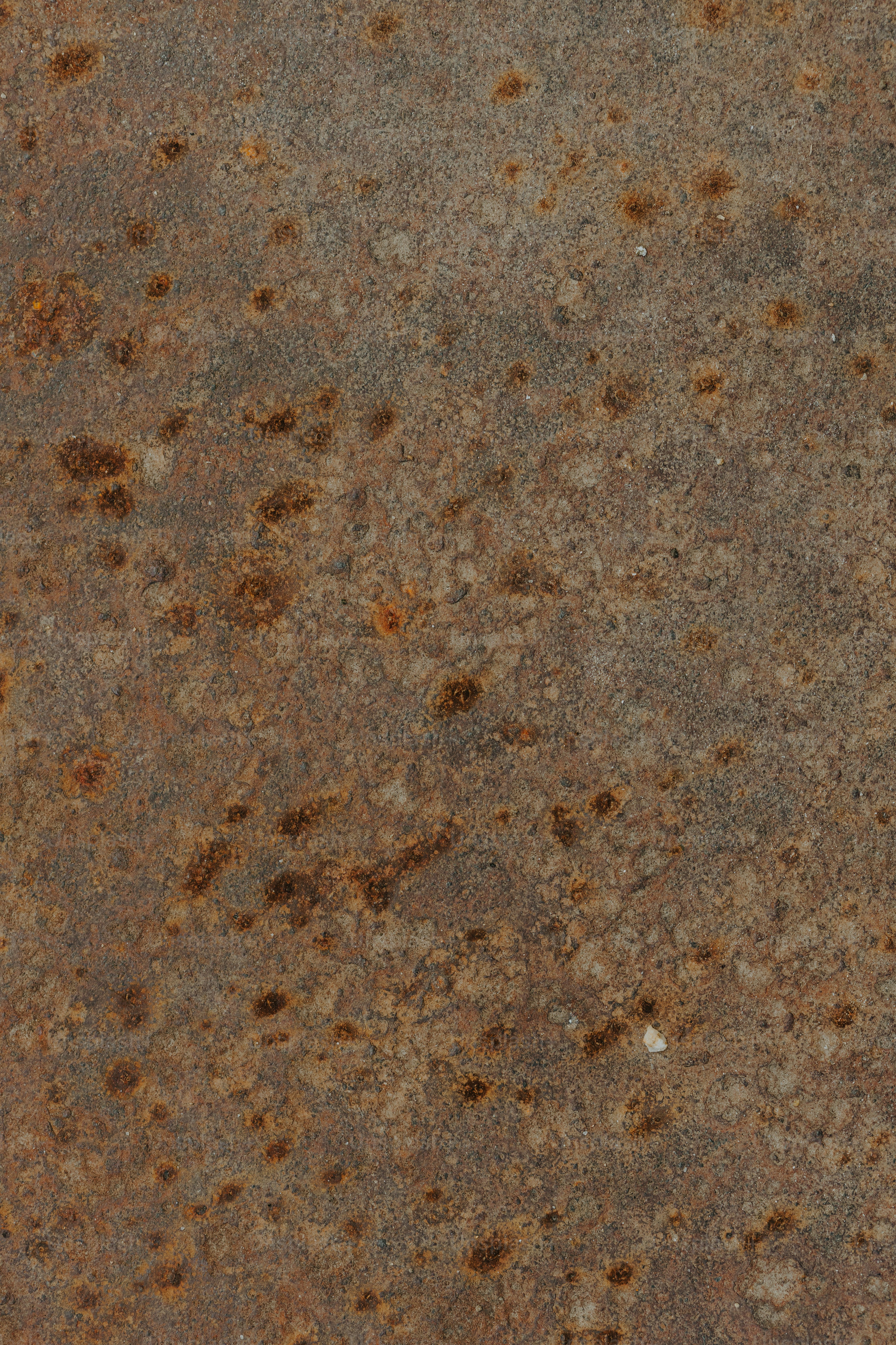 a close up of a metal surface with brown spots