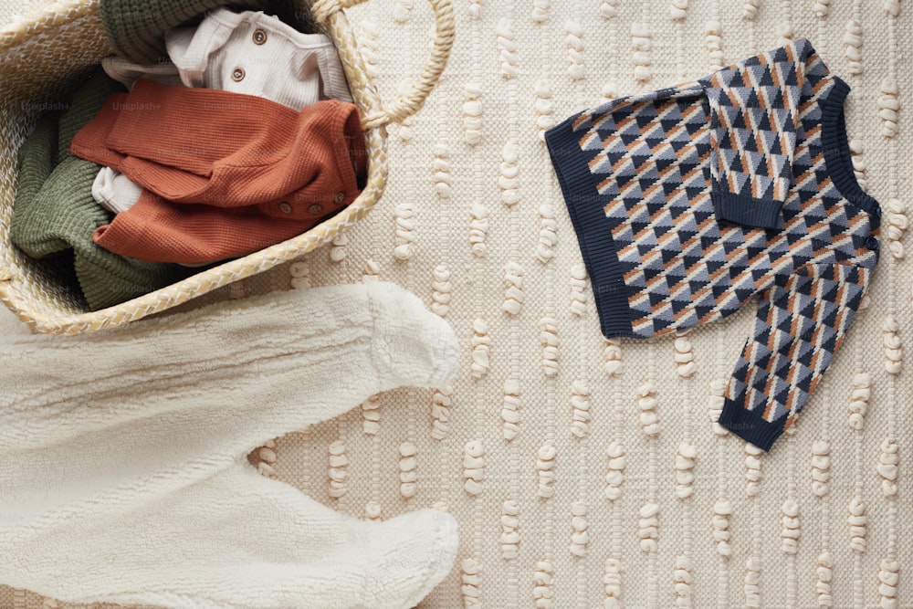 a basket filled with clothes next to a pair of gloves