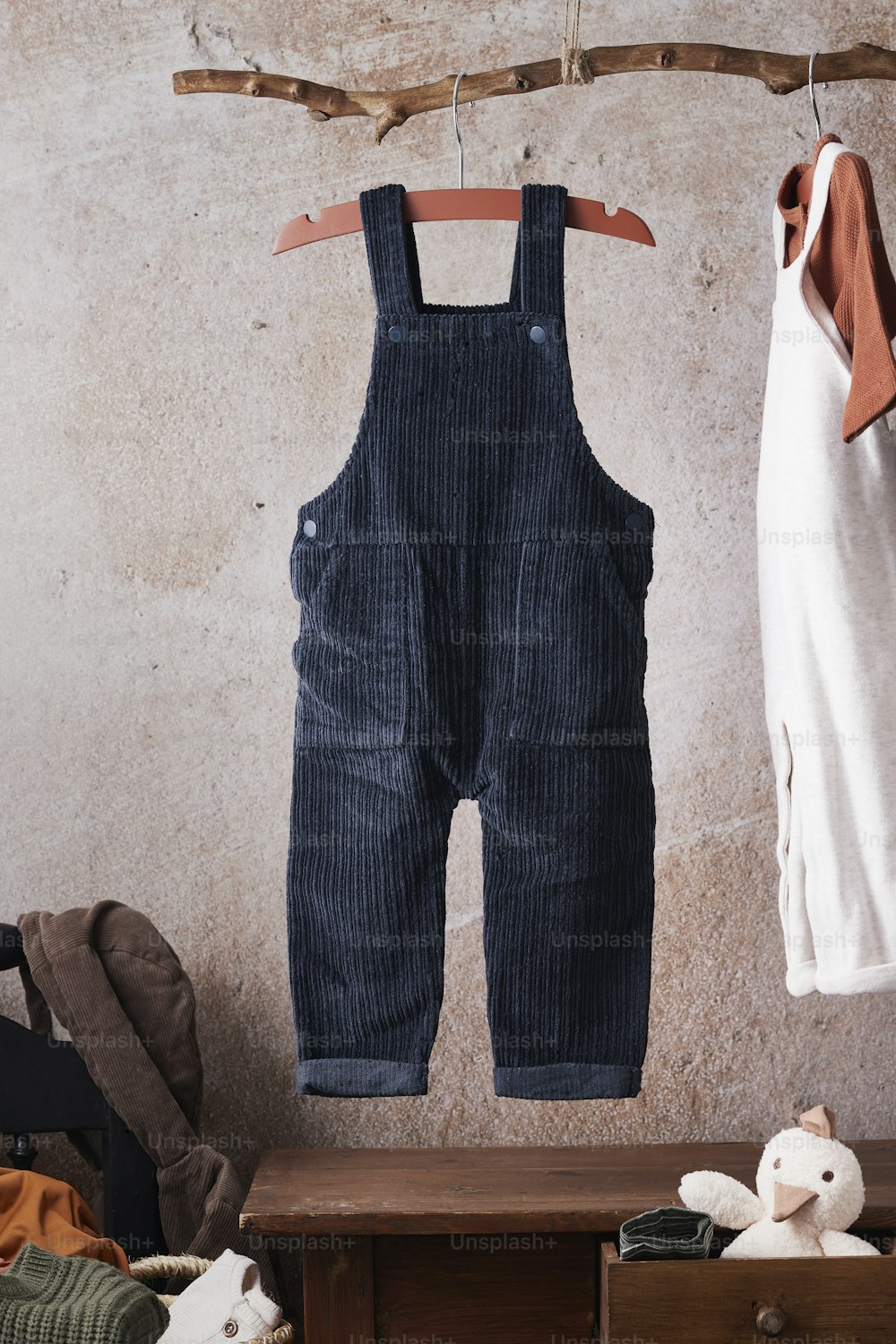 a pair of overalls hanging on a clothes rack