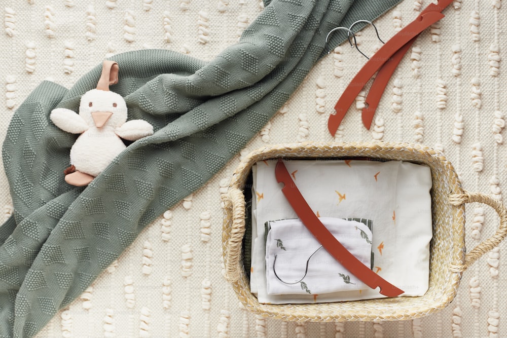 um presente de bebê em uma cesta com um cobertor e um bicho de pelúcia