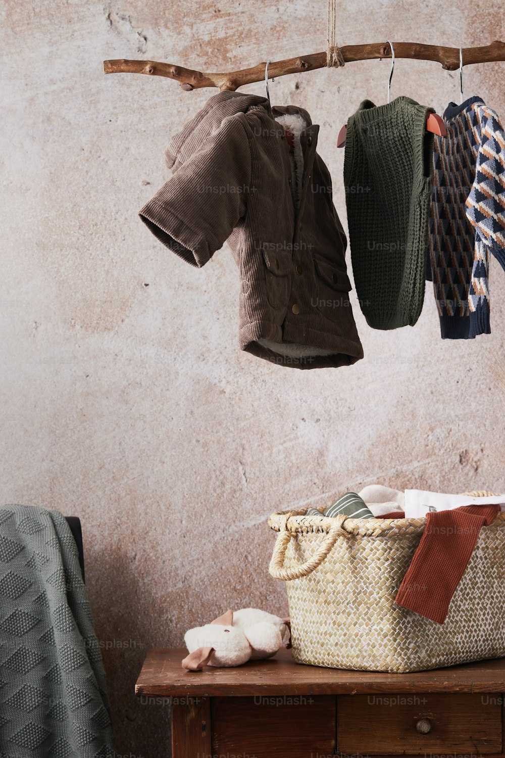 a wooden table topped with a basket filled with clothes