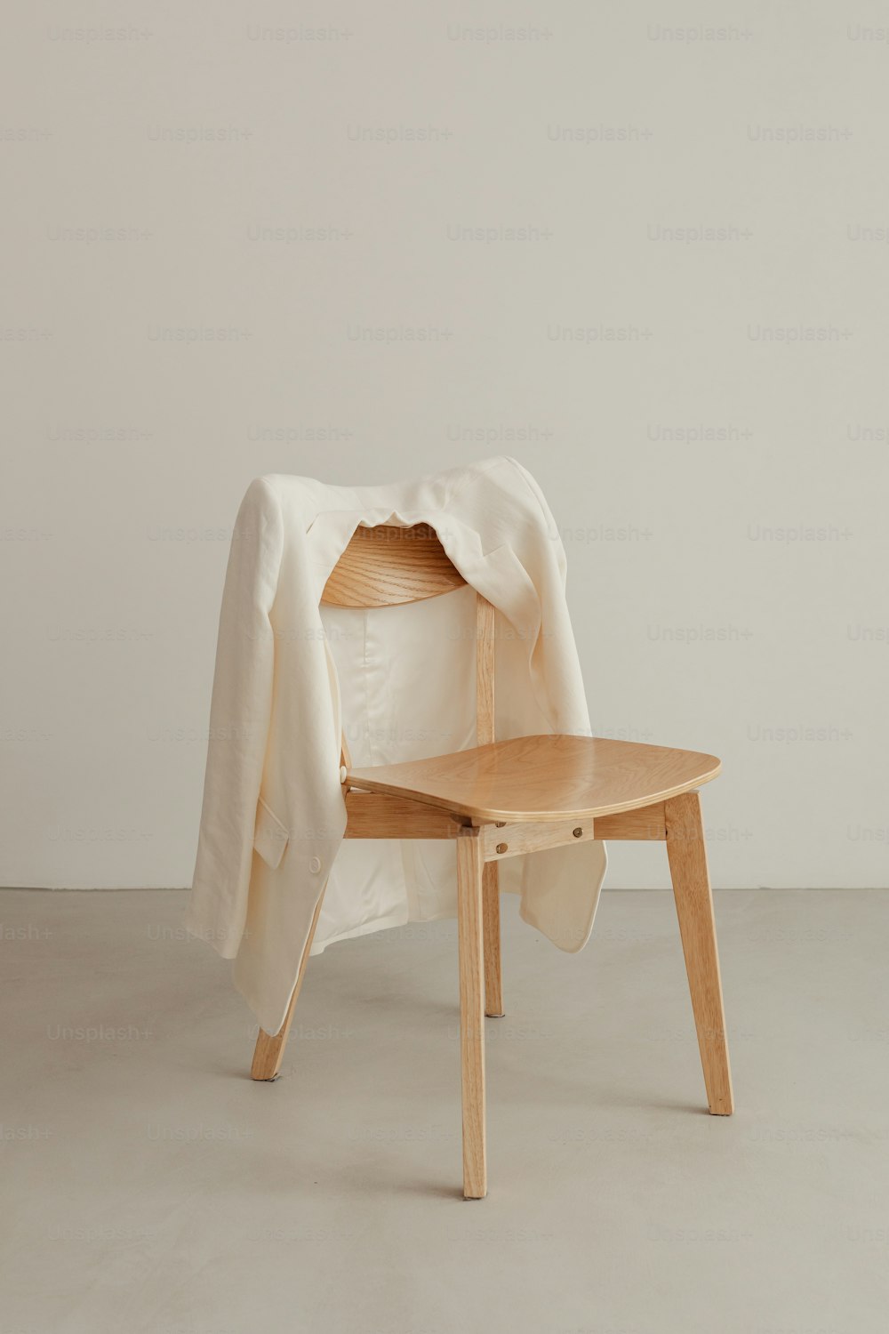 a wooden chair with a white blanket on top of it