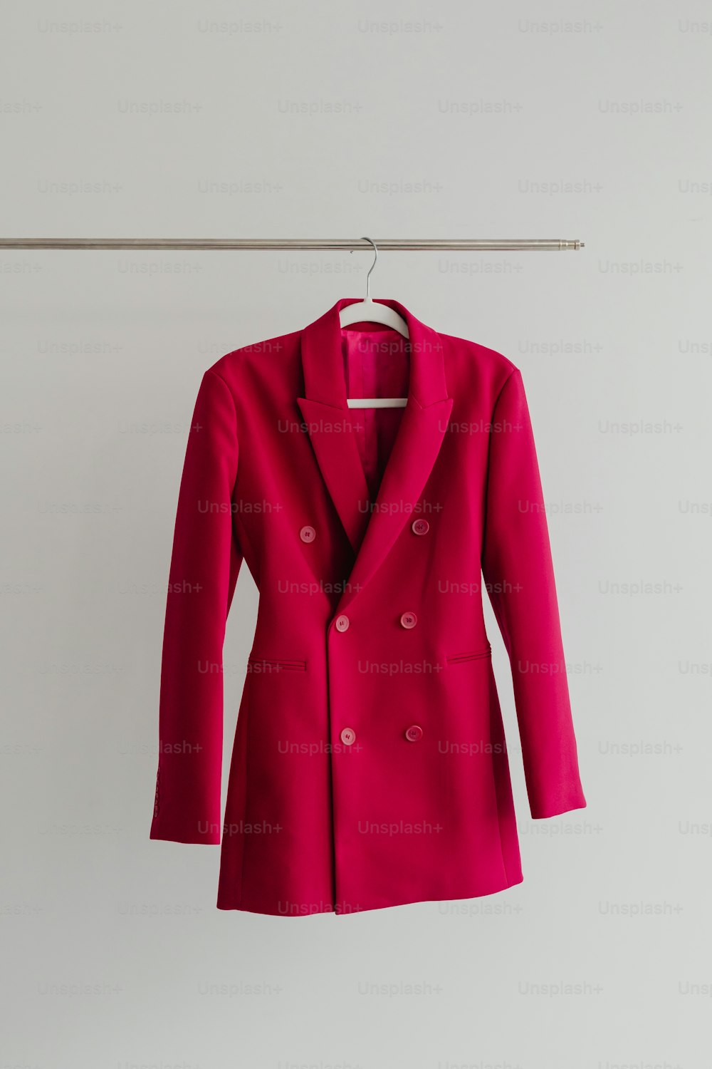 Una giacca rossa appesa a una linea di vestiti