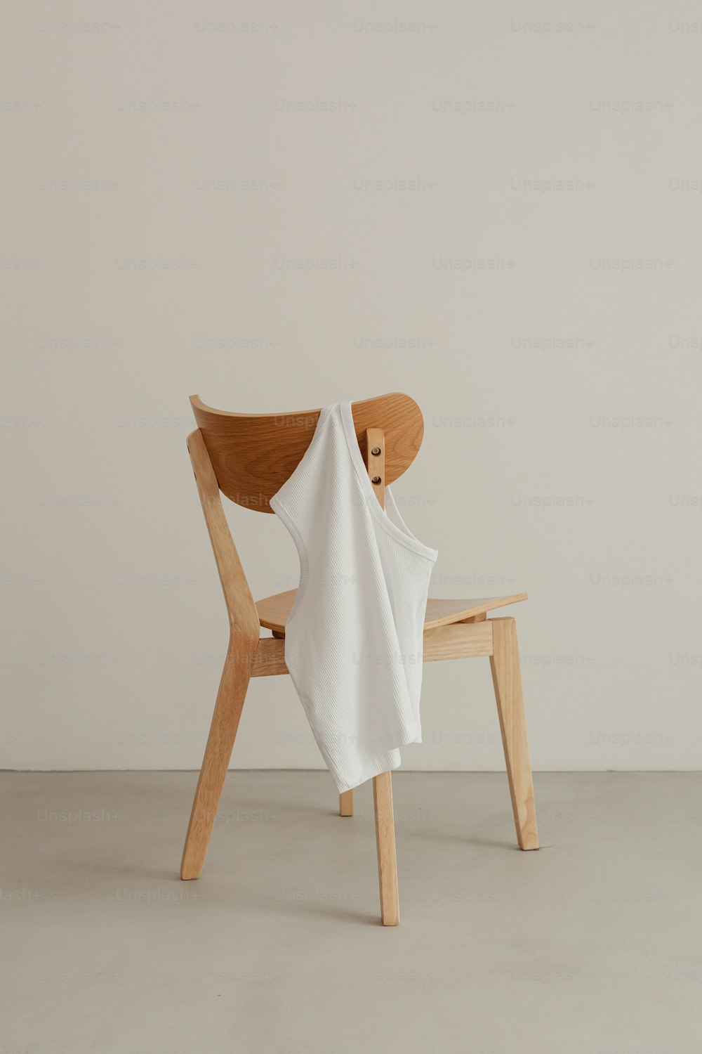 uma cadeira de madeira com um pano branco sobre ela