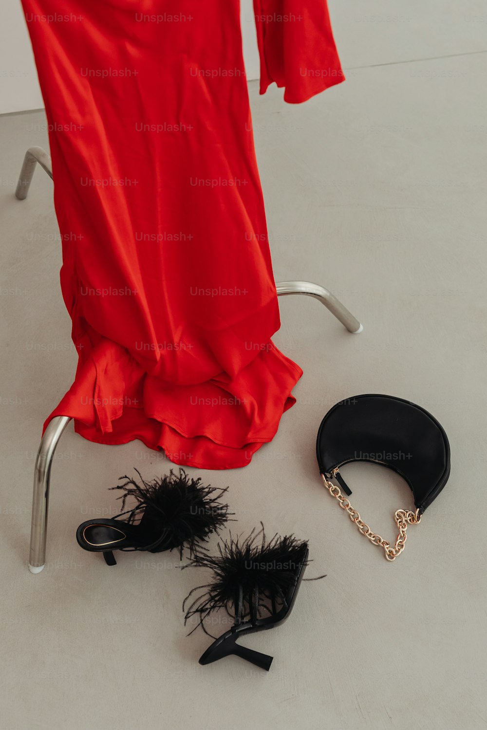 rotes Kleid und Schuhe einer Frau auf weißem Boden