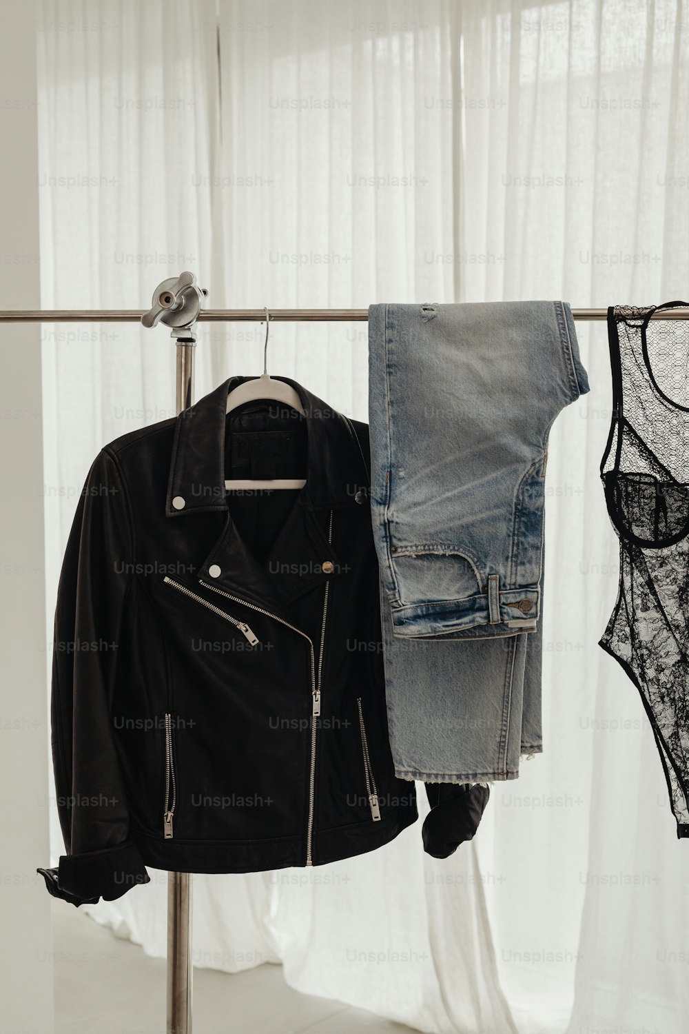 a pair of jeans and a jacket hanging on a clothes rack