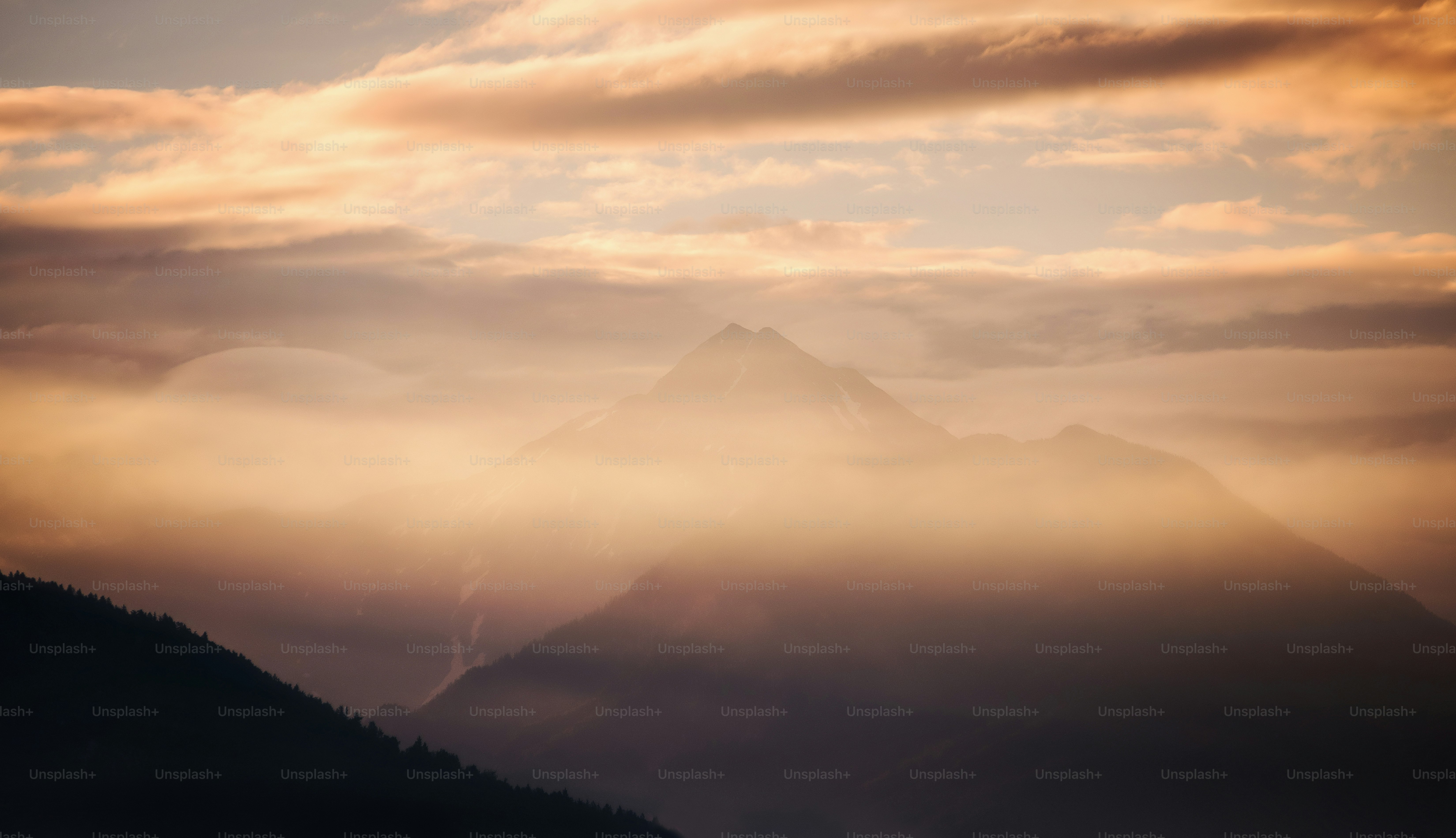 une vue d’une chaîne de montagnes avec des nuages dans le ciel